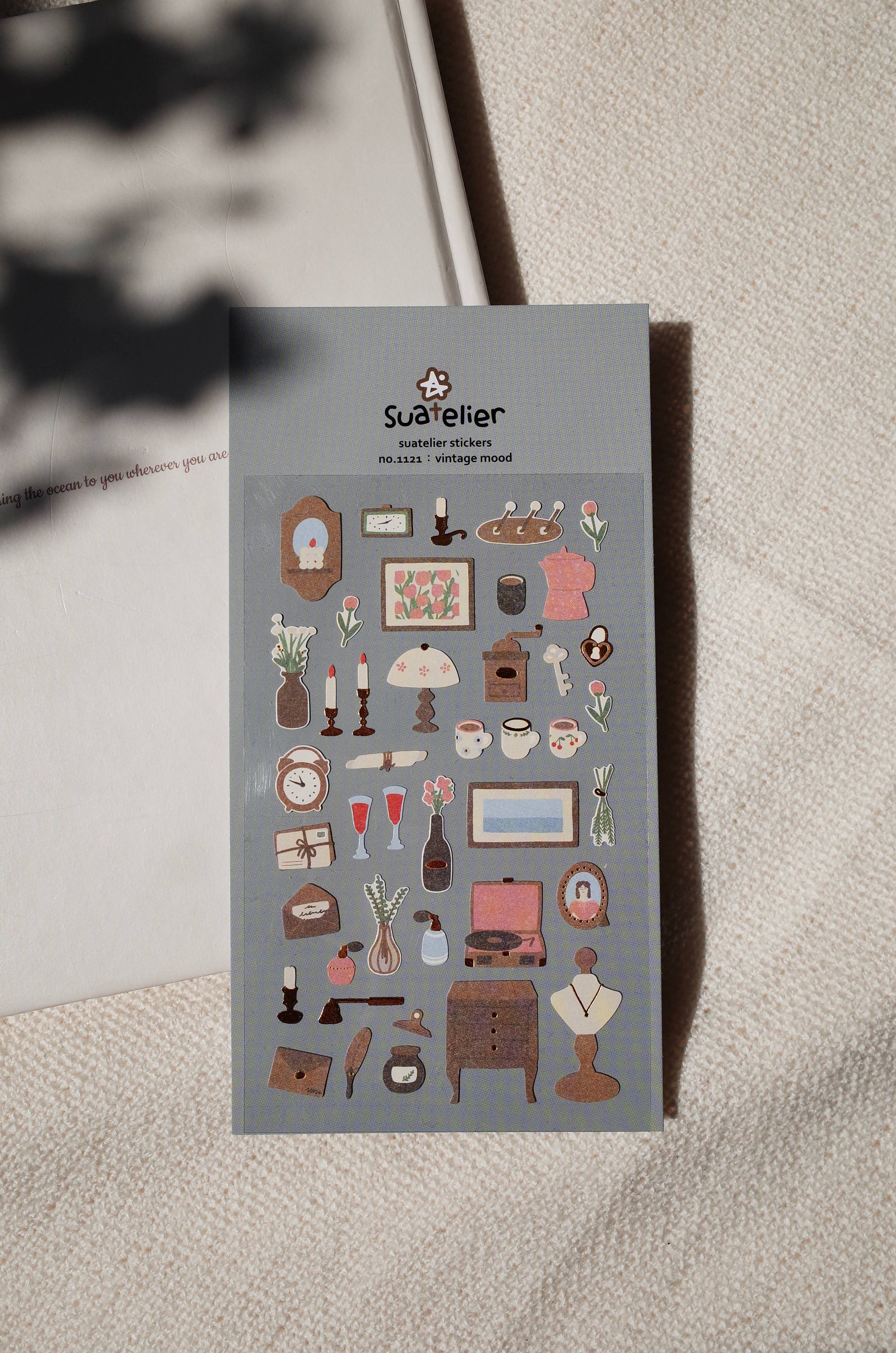 Suatelier Vintage Mood antique deco sticker sheet with illustrated clocks, candles, record player, perfume, and vintage furniture on dusty blue background, made in South Korea