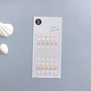 Suatelier Deco.21 seashell mini sticker sheet with rows of shells, starfish, conch shells, and spiral shells in sandy beach tones on light blue background, made in South Korea